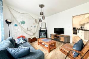 a living room with a couch and a table at Maison de pêcheur Rénovée À 50m des plages in Riantec