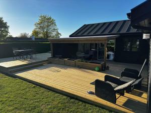 a wooden deck with two chairs and a table at House With A Beautiful View Of The Sea And Bogø in Stubbekøbing