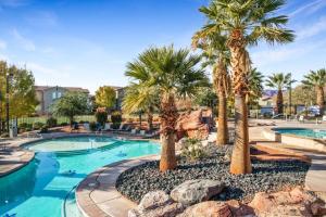 a swimming pool with palm trees in a resort at Four-Bedroom House in Santa Clara