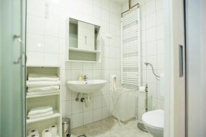 a white bathroom with a sink and a toilet at Fifty Apartments in Zagreb