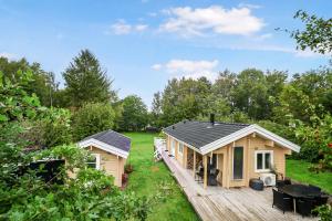 Una pequeña casa con porche y terraza. en The Sun House, en Hundested