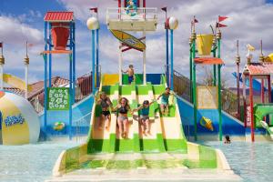 a group of people on a water slide at a water park at Red Sand Hideaway #119 home in Santa Clara