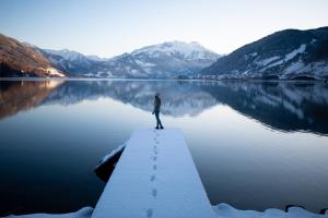 een persoon op een steiger boven een meer bij das zellersee in Zell am See