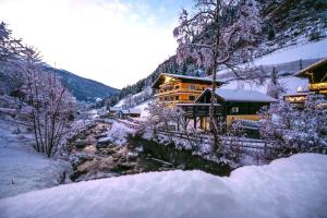 a house in the snow next to a mountain at Hotel Stubnerhof in Bad Gastein