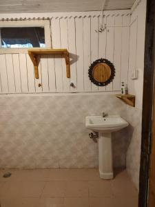 a bathroom with a white sink and a window at Perfect Home for Stay in Jibhi