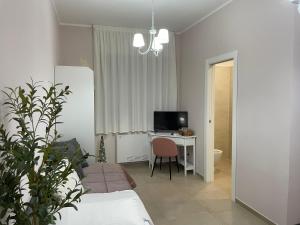 a living room with a table and a desk with a television at B&B Tregì in Lamezia Terme