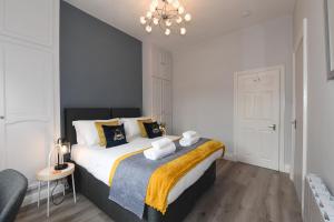 - une chambre avec un grand lit et un lustre dans l'établissement King's View - Private Parking - Overlooking Harrogate Convention Centre, à Harrogate