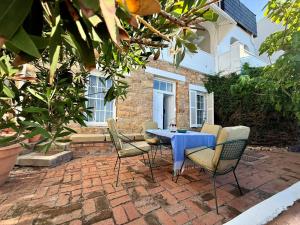 una mesa y sillas sentadas en un patio de ladrillo en 'The Stone Cottage' - Charming, Private and On the Beach - Sleeps 2, en Ciudad del Cabo