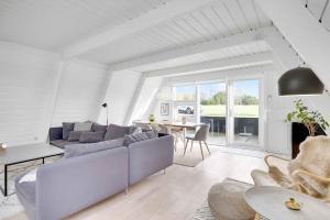 ein Wohnzimmer mit Sofa und Tisch in der Unterkunft Summer House At Himmerland Golf Resort in Farsø