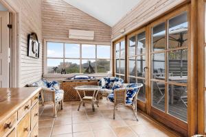 a dining room with chairs and a table and windows at Welcoming Holiday Home Right Down To The Water in Rørvig