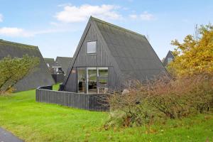 ein schwarzes Haus mit einem Gameradach in der Unterkunft Summer House At Himmerland Golf Resort in Farsø