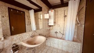 a bathroom with a sink and a bath tub at Ferienwohnung Sonnenblick in Arrach in Arrach +12 photos