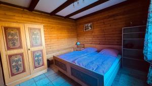a bedroom with a bed in a wooden room at Ferienwohnung Sonnenblick in Arrach in Arrach