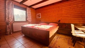 a bedroom with a bed in a wooden room at Ferienwohnung Sonnenblick in Arrach in Arrach