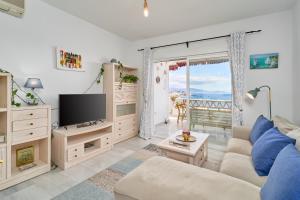 ein Wohnzimmer mit Sofa und Fernseher in der Unterkunft Vista al Mar in La Herradura