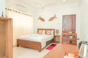 ein Schlafzimmer mit einem Bett in einem Zimmer in der Unterkunft R2 Guest - HIKKADUWA in Hikkaduwa