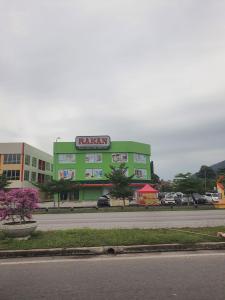 a green building with a sign on the side of a street at SSS Homestay 5 mins to Afamosa Resort 6 mins to Tampin Waterpark in Tampin +56 photos