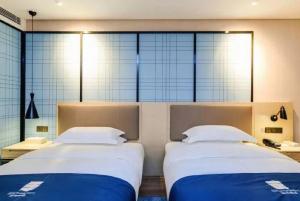 Ένα ή περισσότερα κρεβάτια σε δωμάτιο στο Yishang Hotel Binzhou Boxing Ginza Branch
