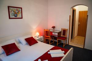 a bedroom with a bed and a desk and a table at Guest House Cesic in Dubrovnik
