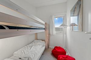 a small bedroom with a bunk bed and red luggage at Cozy Holiday Apartment In The Center Of Søndervig Close To The North Sea in Ringkøbing