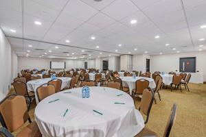 a room filled with tables and chairs with white table cloth at Quality Inn in Ottawa +34 photos