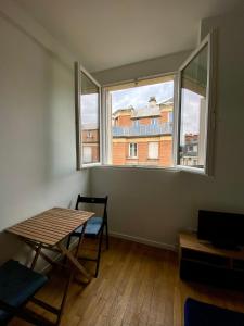 une salle à manger avec une table et deux fenêtres dans l'établissement Appartement entier avec une chambre proche Tour Eiffel, à Paris