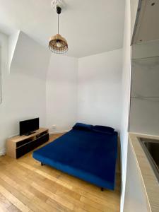 une chambre avec un lit bleu dans une pièce blanche dans l'établissement Appartement entier avec une chambre proche Tour Eiffel, à Paris