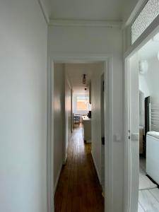 - un couloir avec des murs blancs et du parquet dans l'établissement Appartement entier avec une chambre proche Tour Eiffel, à Paris