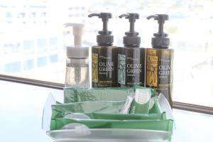a container with four bottles of hair products on a window at Route Inn Grantia Ishigaki in Ishigaki Island