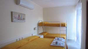 a small room with two bunk beds and a window at Hotel Santa Rosalia in Marina di Camerota