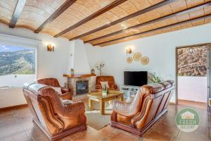 a living room with leather chairs and a fireplace at Casa de la Luz - lovely family villa in Arenas