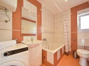 a bathroom with a sink and a toilet and a tub at Apartments Angelina - 2min to the beach in Karlobag +18 photos