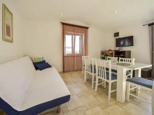 a room with a bed and a table and chairs at Apartments Angelina - 2min to the beach in Karlobag