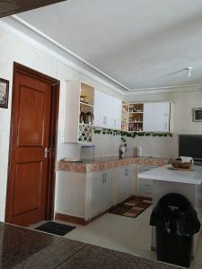 a kitchen with white cabinets and a brown door at Annodas Homes Milimani in Kisumu