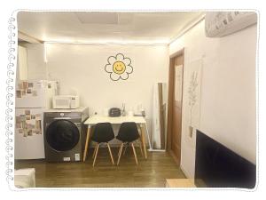 a small kitchen with a table and a refrigerator at Yong Yong House in Seoul