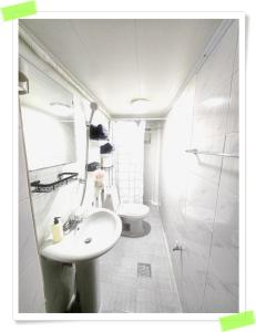 a white bathroom with a sink and a toilet at Yong Yong House in Seoul