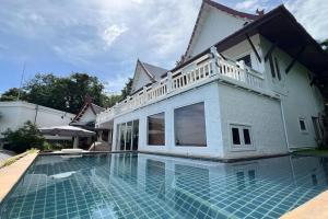a house with a swimming pool in front of a house at Panorama Ocean Villas, Kamala in Surin Beach