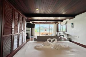 two swans sitting on a bed in a room at Panorama Ocean Villas, Kamala in Surin Beach +38 photos