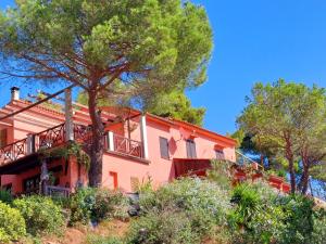 an orange house on a hill with trees at two-room apartment with parking space in Rio nellʼElba
