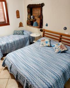 a bedroom with two beds and a table with a lamp at Appartamento Bluette in Rio nellʼElba