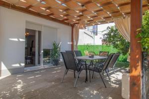a patio with a table and chairs under a pergola at Holiday Home Peaceful Oasis with Pool in Drvenik