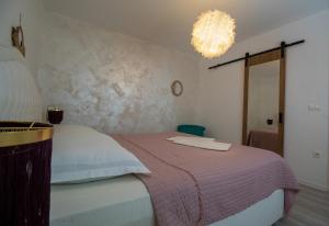 a bedroom with a bed and a chandelier at Holiday Home Peaceful Oasis with Pool in Drvenik +108 photos