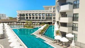 an aerial view of a hotel pool with umbrellas at The X Belek in Belek