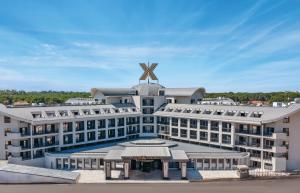 a large white building with a windmill on top of it at The X Belek in Belek