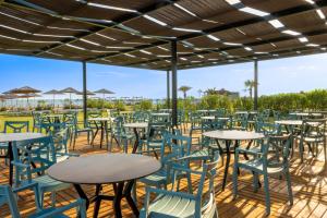 an empty patio with tables and chairs under awning at The X Belek in Belek