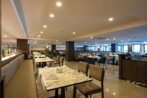 a restaurant with tables and chairs and a bar at The X Belek in Belek