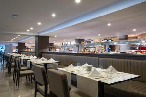 a restaurant with tables and chairs and a kitchen at The X Belek in Belek