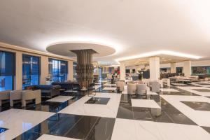 a lobby of a hotel with chairs and tables at The X Belek in Belek