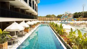 a pool at a resort with a roller coaster at The X Belek in Belek