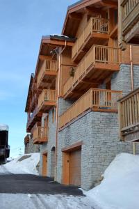 a building with wooden balconies on the side of it at Chalet Le Quartz in Val Thorens